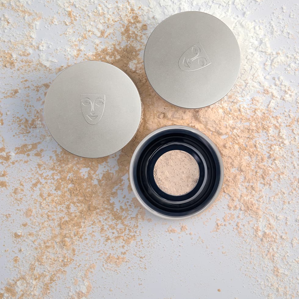 A finishing powder compact with a powder brush across it